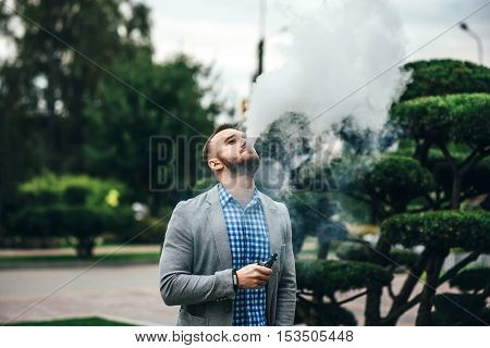 Men With Beard Smoking Electronic Cigarette Outdoor