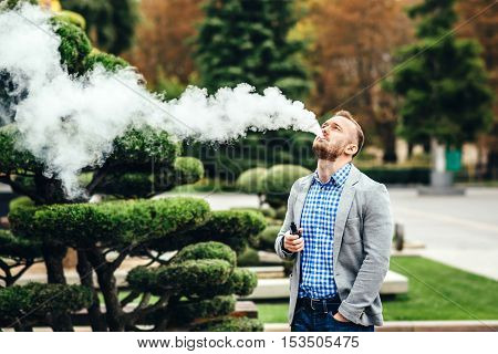 Men With Beard Smoking Electronic Cigarette Outdoor