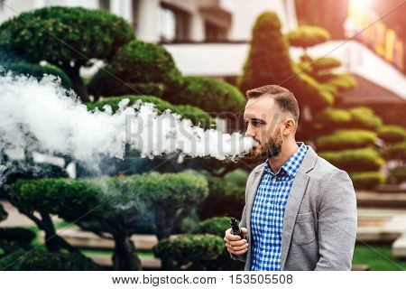 Men With Beard Smoking Electronic Cigarette Outdoor