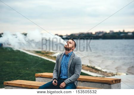 Men With Beard Smoking Electronic Cigarette Outdoor