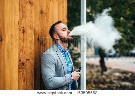 Men With Beard Smoking Electronic Cigarette Outdoor