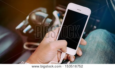 Man's hands holding smart phone inside a car