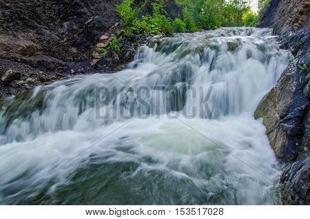 falling water in the morning mist. falling water in the dense morning fog. Water falling from a cliff. falling from a height of water. falling water in the fog. thick morning fog in the summer forest.