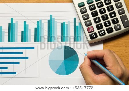 Business man write on financial chart and graph