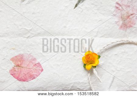 White mulberry paper with pink petal texture background and orange handmade flower