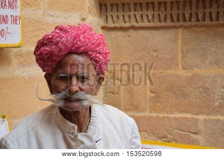 JAISALMER, RAJASTHAN, INDIA - FEBRUARY 10, 2016 - Portrait of an unidentified aged indian man with mustaches and traditional red turban