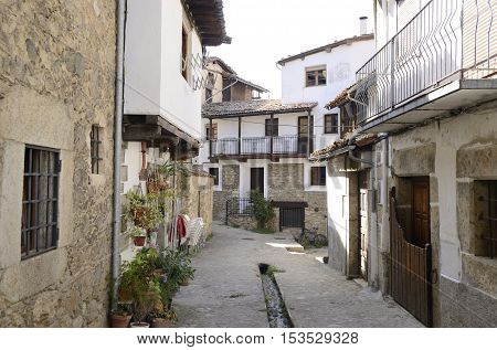 Small channel with clear water collected from the snowfields of the mountain at the floor of the street in Candelario a village of the province of Salamanca Spain.