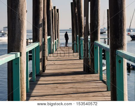 WALVIS BAY NAMIBIA - JUNE 22 2016: Person standing at the end of a bridge in the port in Walvis Bay Namibia.