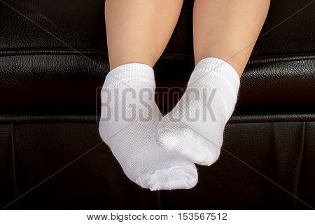 Young School Girl Student Feet Wearing White Socks and Stting on a Leather Sofa