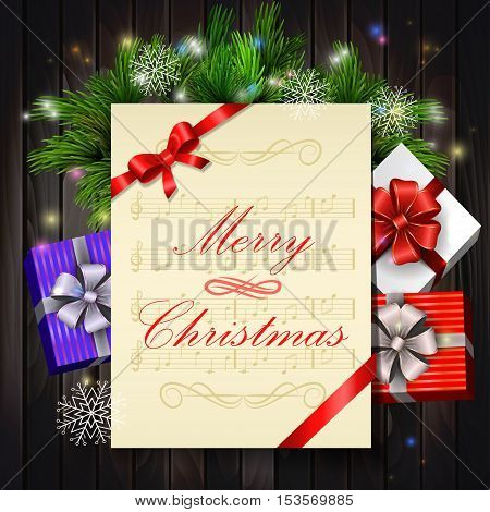 Christmas card with notes and music with holy and gift boxes on wooden background
