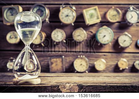 Old hourglass as the old way of timing on old wooden table