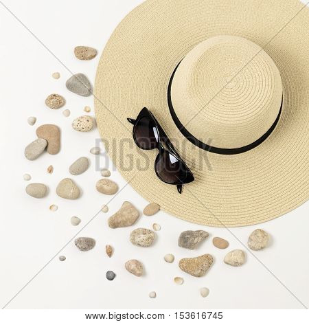 Fashion accessories - hat sunglasses and bracelets. Marine concept sea shells and sea pebbles.
