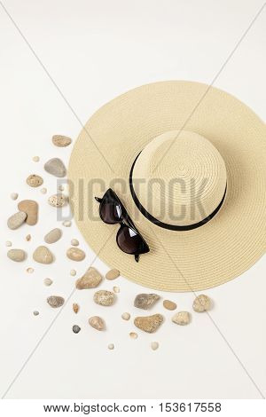 Fashion accessories - hat sunglasses and bracelets. Marine concept sea shells and sea pebbles.