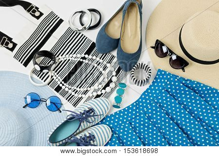 Fashion accessories in black and white and blue colors - hat clothing shoes and bag bracelets and glasses.