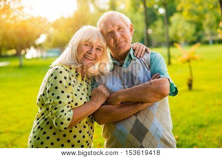 Senior woman hugs man. Couple looking at the camera. Hearts united by love. Support and trust are priceless.