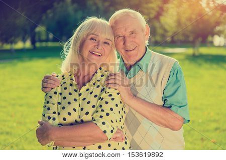 Older couple outdoor. Two people smiling. Happiness given by fate. Let the sun shine brighter.