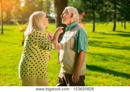 Couple pointing at each other. Man and woman standing outdoor. Escalation of conflict. You're acting like a fool.