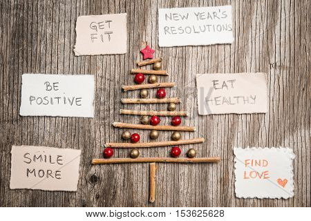 Christmas Tree And New Year Resolutions On Rustic Wooden Background