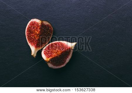 figs on a dark wood background. tinting. selective focus on the front figs slice in the bowl