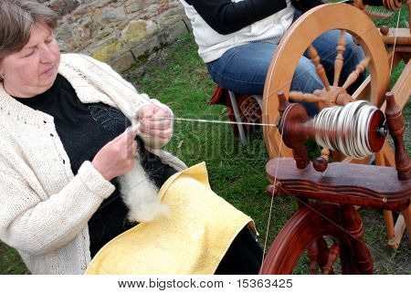 RATIBORICE, Tsjechië - 24 APRIL: oudere vrouw spinnen van wol op traditionele spinnewiel - Th