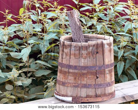 Vintage wooden bucket in the yard of the rural house. Close-up. Ural, Russia.