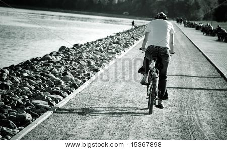 Mand på cykel. Tonet billede med høj kontrast.