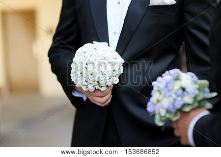 Groom And A Bestman Holding Flowers