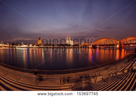 Illuminated Cologne Cathedral and bridge at night in Cologne, Fisheye perspective