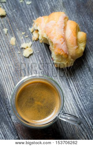 Closeup of a coffee and croissant on old wooden table