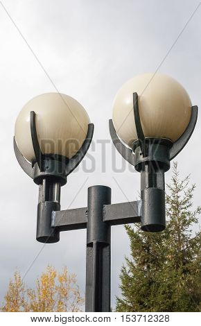 Stylish city lamps against the background of the cloudy sky