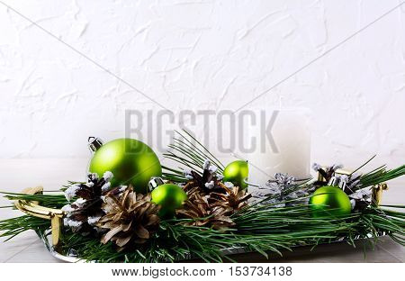 Christmas background with holiday ornaments and candle centerpiece. Christmas decoration with pine cones. Christmas greeting background. Copy space.