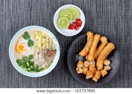 Rice porridge with mined pork and chicken lever served with side dish as Patongko (deep-fried dough stick) and spicy sour fillin.