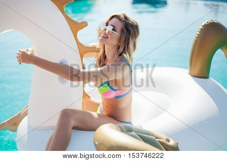 Sexy woman in bikini enjoying summer sun and tanning during holidays in pool. Woman in swimming pool. Sexy woman in bikini