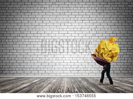 Builder man carrying paper ball on his back