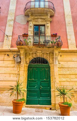 Baroque facede decorated with flowers in Italy. Beautiful travel photo. Colorful background texture with architecture and flowers.