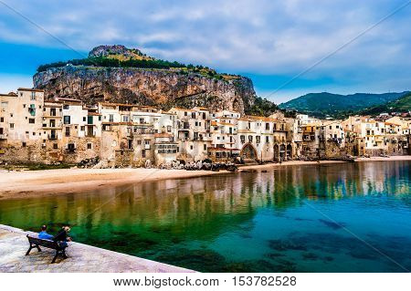 View on habour and old houses in Cefalu at sunset, Sicily. Beautiful townscape of old italian town. Travel photography.