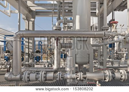 Details of a modern natural gas processing plant with pressure dials on gasworks pipes