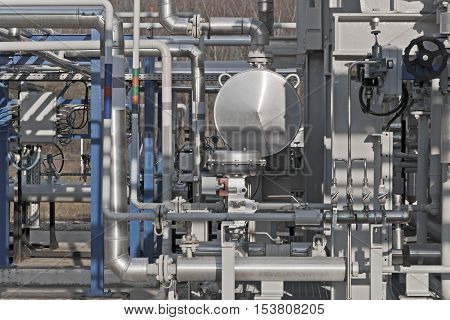 Details of a modern natural gas processing plant with pressure dials on gasworks pipes
