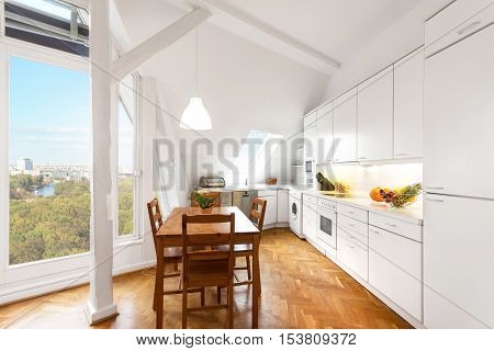 White Kitchen With Wooden Floor In Beautiful Home -