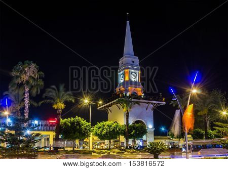 Illuminated central clock tower in Kemer Turkey. Kemer a seaside resort on the Mediterranean coast of Turkey Antalya Province. Night view.