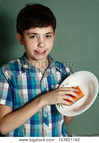 happy preteen boy wash dishes close up portrait on blue wall background