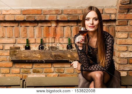 Woman Tasting Wine In Rural Cottage Interior