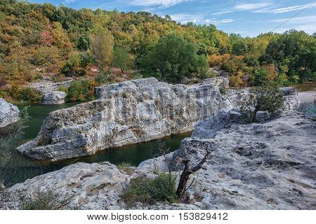 At the foot of the hill on which La Roque sur Cèze in France lies swirl spectacular waterfalls and rapids of the Cascades du Sautadet.