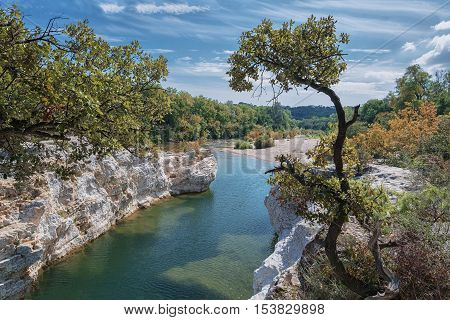 At the foot of the hill on which La Roque sur Cèze in France lies swirl spectacular waterfalls and rapids of the Cascades du Sautadet.