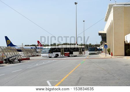 LUQA MALTA - APRIL 18: The bus and building of Malta International Airport on April 18 2015 in Luqa Malta. More then 16 mln tourists is expected to visit Malta in year 2015.