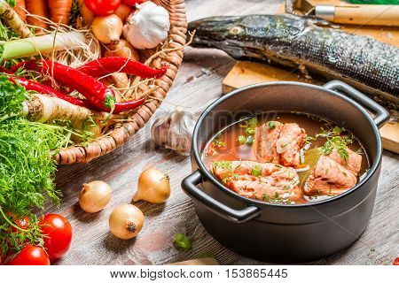 Fresh ingredients for fish soup on old wooden table