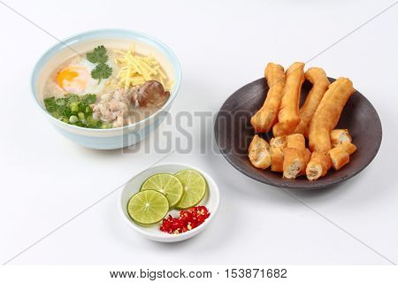 Rice porridge with mined pork and chicken lever served with side dish as Patongko (deep-fried dough stick) and spicy sour fillin.