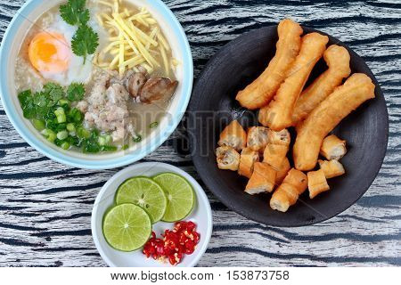 Close up of rice porridge with mined pork and chicken lever served with side dish as Patongko (deep-fried dough stick) and spicy sour filling.