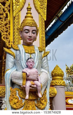 Myanmar goddess statue holding child statue in Buddhist temple in Dawei Myanmar.