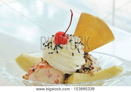 Banana split ice cream on glass table.